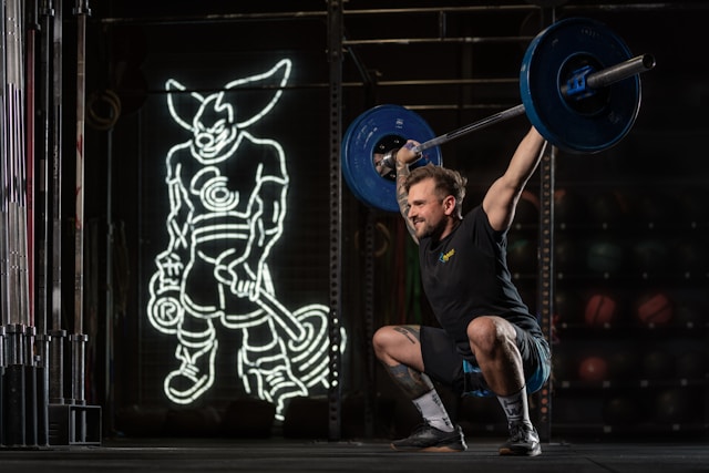 a-man-squatting-with-a-barbell-in-his-hands
