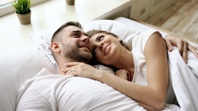 a-satisfied-and-happy-couple-lying-in-bed-smiling-at-each-other
