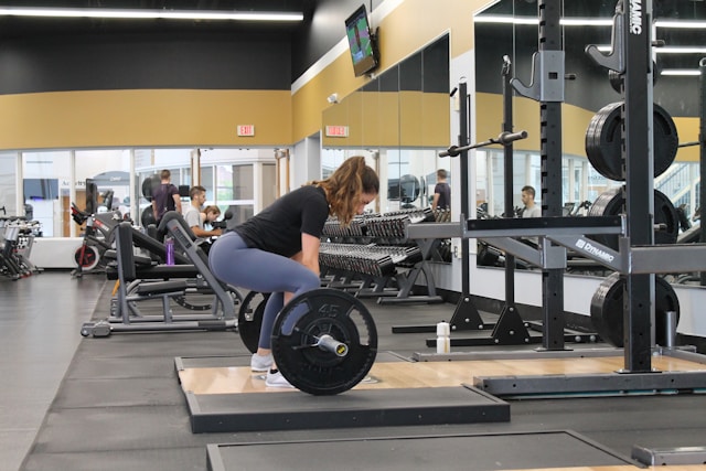 Woman lifting a barbell in the gym to build muscle after menopause.