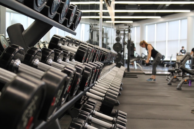 Woman in a gym with strength training equipment to protect muscle during GLP-1 weight loss.